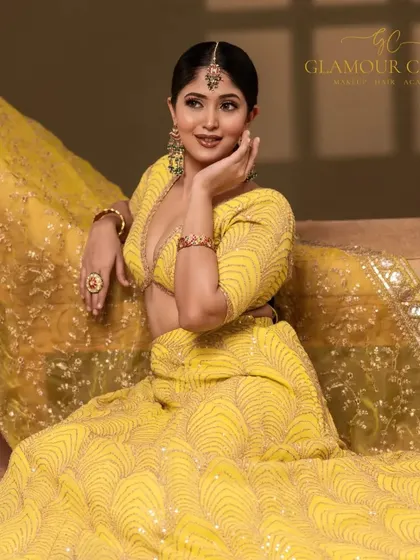 Embrace the glow. This portrait highlights a vibrant yellow lehenga, perfect for a Haldi or Mehendi ceremony. The lighting brings out the rich color and detailed embroidery.
