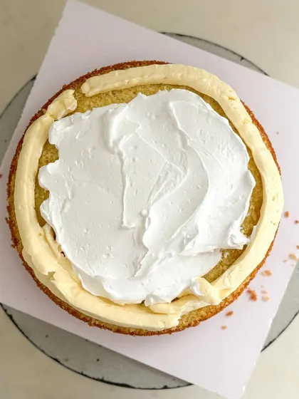 Spreading a layer of light whipped cream before adding the fruit.