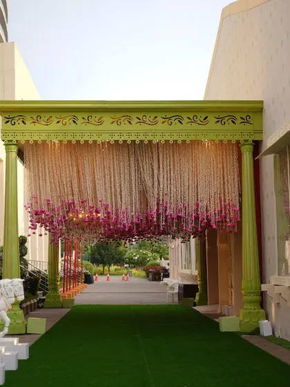 The grand floral entrance welcoming the baraat, with a curtain of white and pink flowers setting a soft and romantic tone.