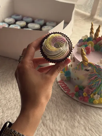 A magical unicorn birthday cake, complete with a golden horn and colorful mane. The matching cupcakes with rainbow frosting completed the enchanting theme for a third birthday party.