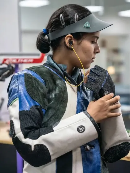 A shooter prepares for her turn, a moment of quiet focus and mental preparation.