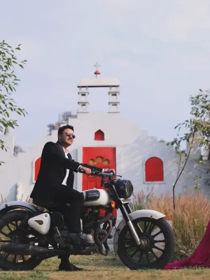 A stylish and unique outdoor shoot at a location with distinct architecture, featuring a couple posing with a classic motorcycle for a cool, modern vibe.