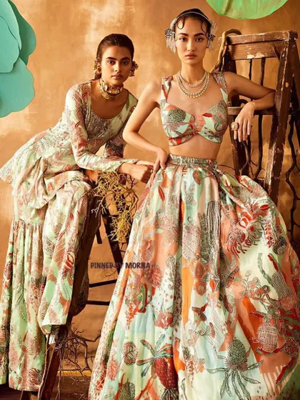 This look combines a sharara-style bottom with a lehenga's grandeur. The floral green ensemble includes a detailed choli and a matching sharara set, offering a unique silhouette.