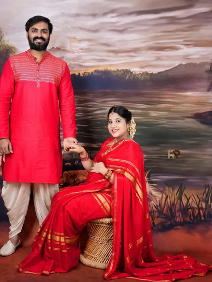 A classic family portrait in traditional wear. The couple, dressed in red, holds hands, creating a beautiful image of unity and love.