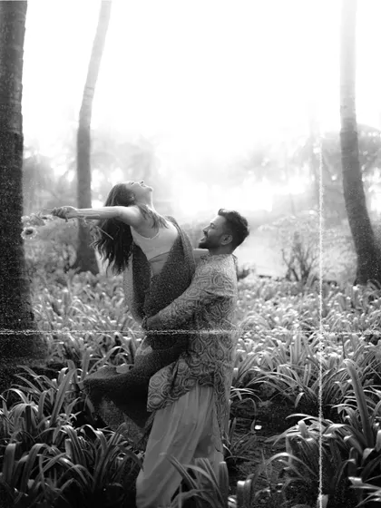 The same joyful lift, captured in a classic black and white film style. This artistic choice adds a timeless and dramatic feel to the moment.