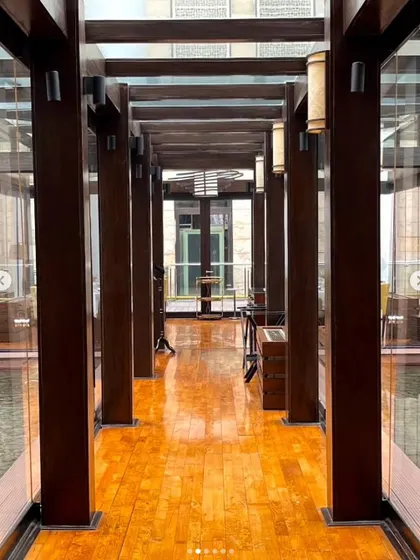 The walkway at our New Delhi location, with its polished wooden floors and glass walls overlooking the water body. It sets a tone of modern elegance from the moment you enter.