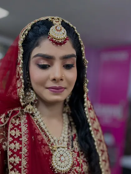 A close-up of the bride's makeup, featuring soft gold and pink eyeshadow, winged liner, and a matte lip.