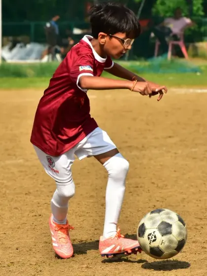 A player demonstrates precise ball control during a match. The focus and technique on display are a direct result of our dedicated training sessions.