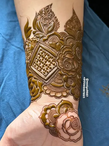 I love combining different elements. Here, I've mixed a floral Gulf style with a geometric 'jaali' (net) pattern on the wrist for a unique, modern look.