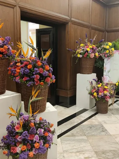 Large wicker baskets filled with colorful flowers at the entrance of the prestigious Taj Mahal Palace hotel for a Mehendi ceremony.