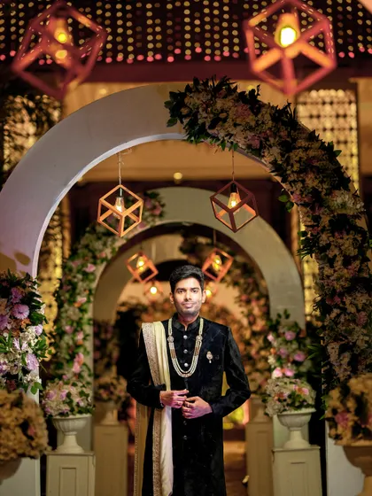 A portrait of the groom at the same reception, looking sharp against the beautifully lit decor.
