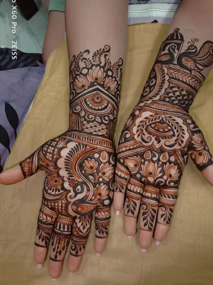This design showcases a mix of bold and fine lines. It features prominent lotus and peacock motifs, which are symbols of beauty and grace, combined with delicate jaali (net) patterns for a balanced composition.