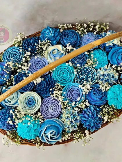 A stunning cupcake bouquet featuring an array of blue-toned floral piping designs.