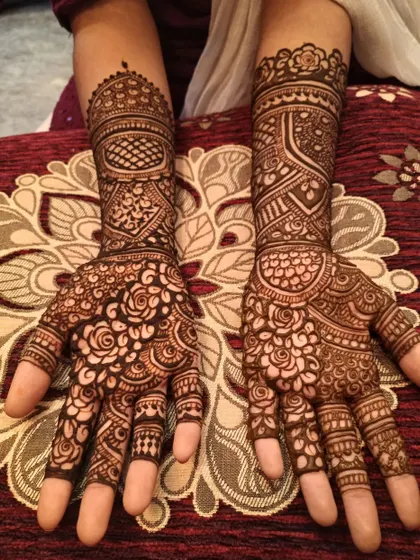 I love the richness of this design, which combines swirling roses on the palms with geometric patterns on the wrists and arms. It's a classic choice for any festive occasion.