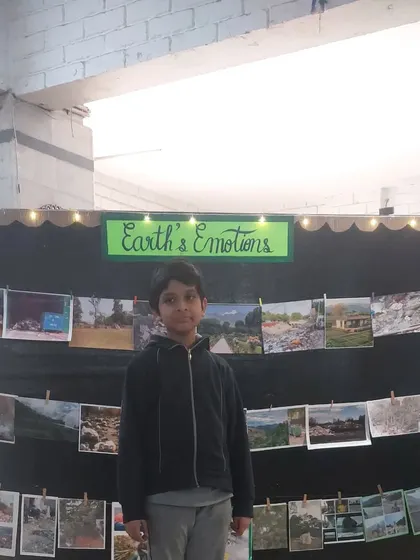 A student stands by his "Earth's Emotions" display, which was part of his science exhibition project. It was a creative way to show the impact of pollution on our planet.