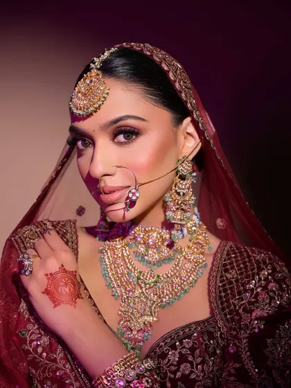 A powerful and confident pose that shows off the complete bridal attire, with makeup that stands out beautifully.