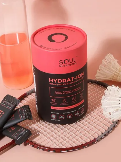 A lifestyle shot for a hydration supplement, styled with a badminton racket and shuttlecocks. This clearly positions the product within the sports and fitness niche, appealing to athletes.