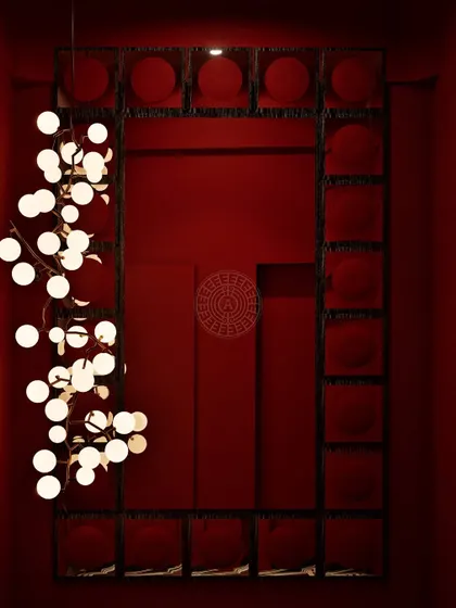 A render of the dramatic, red-drenched corridor leading to the washrooms, featuring a modern globe chandelier that creates an artistic, gallery-like feel.