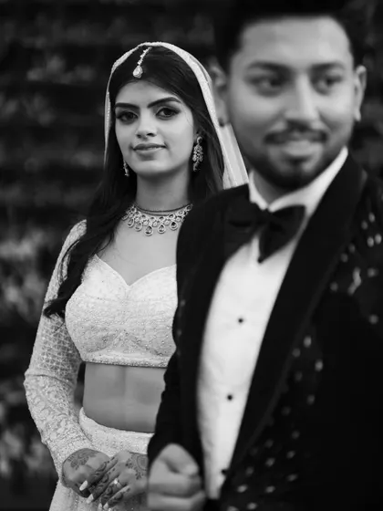 A creative black and white shot using depth of field to focus on the bride while the groom is softly blurred in the foreground. This artistic choice adds a story-telling element to the portrait.