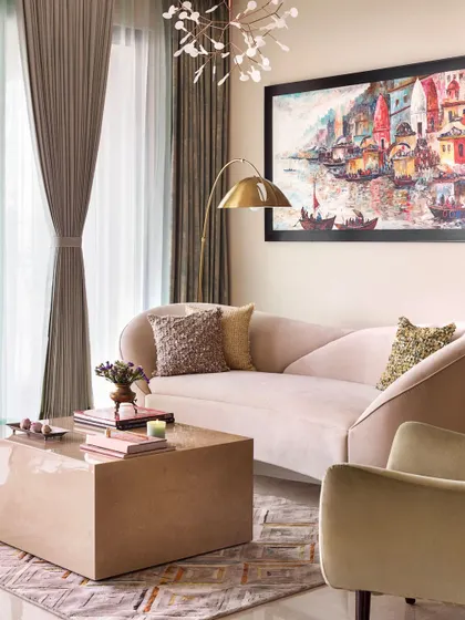 This is one of my favorite views, perfectly summarizing the modern-traditional essence of this home. A modern curved sofa in a soft blush tone is set against a traditional ghat painting, creating a beautiful dialogue between past and present.