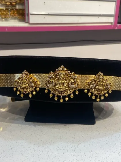 A close-up of a traditional Vaddanam (waist belt) with matching bajuband (armlets). These pieces can be rented separately to complete your bridal look.