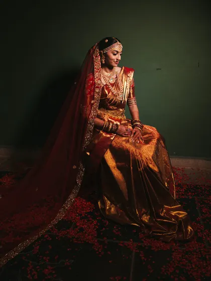 The full bridal look, complete with a silk saree and a flowing veil, captures the grace and elegance of a traditional South Indian wedding. Every element is chosen to create a portrait of timeless beauty.