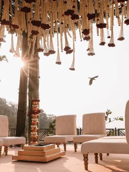 The sun sets behind the mandap, creating a magical golden hour glow for the sunset pheras.