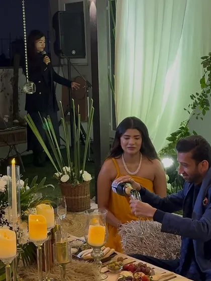 The celebration after the 'yes'. Here, the happy couple enjoys a glass of champagne at their private, beautifully styled table, complete with a live musician in the background to complete the romantic ambiance.