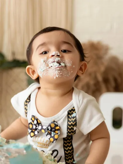 A close-up portrait capturing the messy details of a fun and successful cake smash.