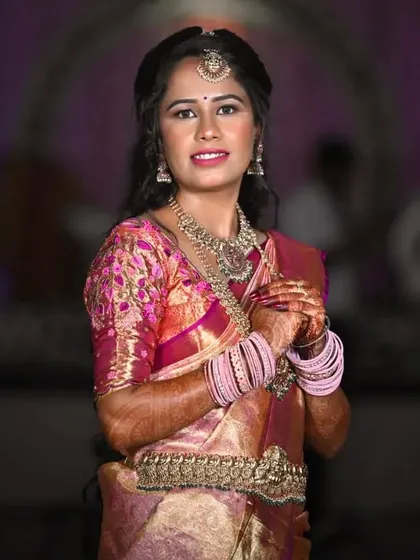 A classic pose showing her complete traditional attire. The makeup brings the whole look together, making her look like a quintessential South Indian beauty.