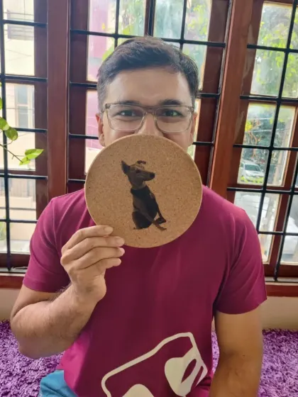 Another view of the custom dog portrait coaster, held proudly by its creator.