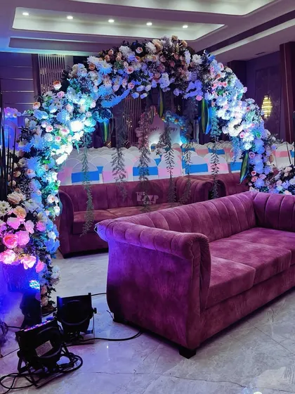 A beautiful floral arch and comfortable seating setup, perfect for a baby shower or an elegant birthday celebration.