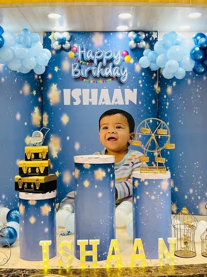 A closer look at the 'Twinkle Twinkle Little Star' theme. The birthday boy is perfectly framed by the custom backdrop, balloon clouds, and themed props like a miniature ferris wheel and bird cages.