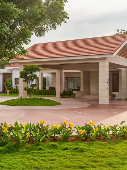 The entrance is designed to be impressive from all angles, with manicured lawns and flowering plants framing the view of the main structure.