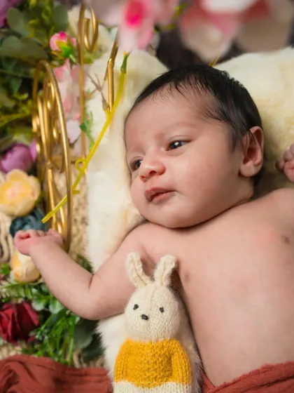 A curious gaze from a garden of dreams. This awake shot shows the baby looking at the flowers, a sweet and interactive moment.
