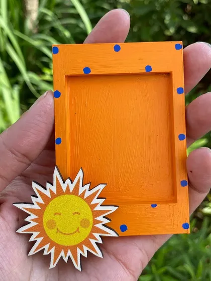 Brighten up your fridge with this cheerful sun-themed photo magnet.