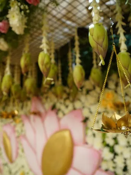 Another detail from the lotus-themed cradle ceremony. The hanging lotus buds and the small brass lotus diya add a delicate and symbolic touch to the overall design.