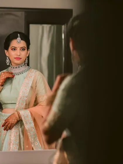 A glimpse of the bride getting ready in front of a vanity mirror. I ensure my brides have a peaceful and organized space to prepare for their big moment.