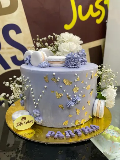 A 2kg lavender cake adorned with gold leaf, macarons, and fresh baby's breath for a touch of elegance.