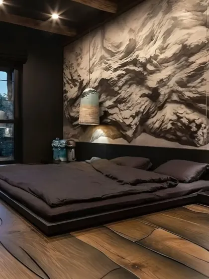 A dramatic and moody bedroom design with a low platform bed and a striking textured accent wall. The dark color scheme and unique flooring create a bold and intimate atmosphere.