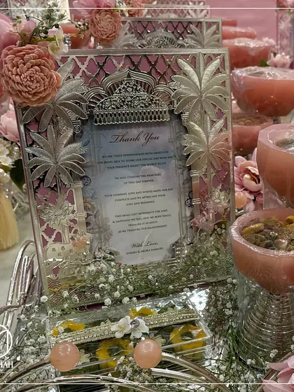 The intricate silver-plated palm tree and palace details on this photo frame add a touch of regality to this thank you hamper, perfectly complementing the soft pink floral and gift arrangement.