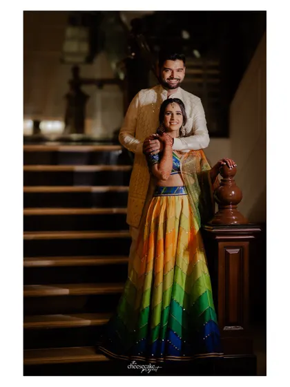 A full-length portrait showing off the couple's vibrant outfits before their colorful Haldi ceremony.