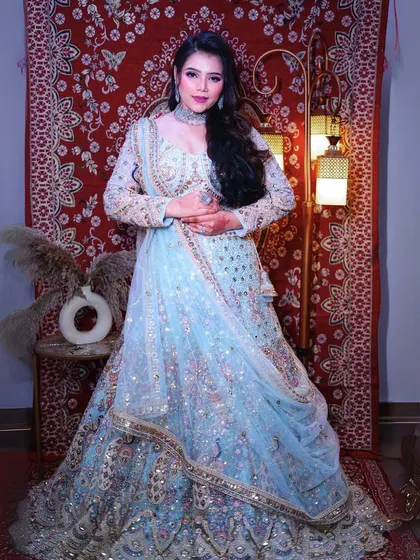 A seated pose showing the beautiful fall of the sky-blue peacock lehenga, perfect for your wedding portraits.
