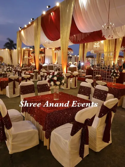 A classic dining setup with round tables, sequined red tablecloths, and elegant chair covers, ready for guests to enjoy a feast.