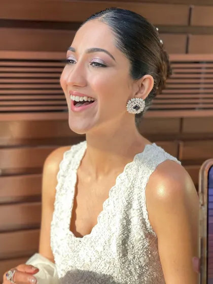 A joyful, candid moment, with the sleek bun keeping the look polished and elegant.