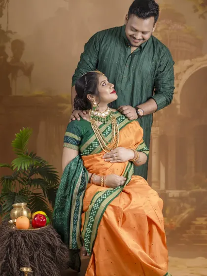A culturally rich portrait of an expecting couple. Dressed in a traditional Odia saree and kurta, they share a loving look in a setting that evokes timeless heritage.