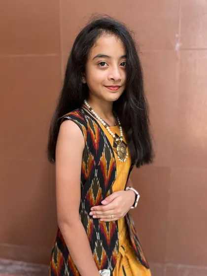 A close-up of the mustard dhoti set, showing the ikat print on the jacket.