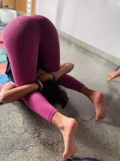 A side view of Ear Pressure Pose. It's important to approach advanced postures like this with patience and care, always listening to your body's limits.