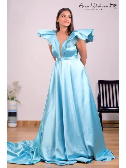 A full-length shot of the sky-blue satin gown, highlighting its flowing trail.
