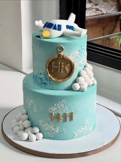 Taking celebrations to new heights. This custom aviation-themed cake was crafted for someone whose journey is as special as their milestone, featuring a handcrafted airplane and personalized initials.